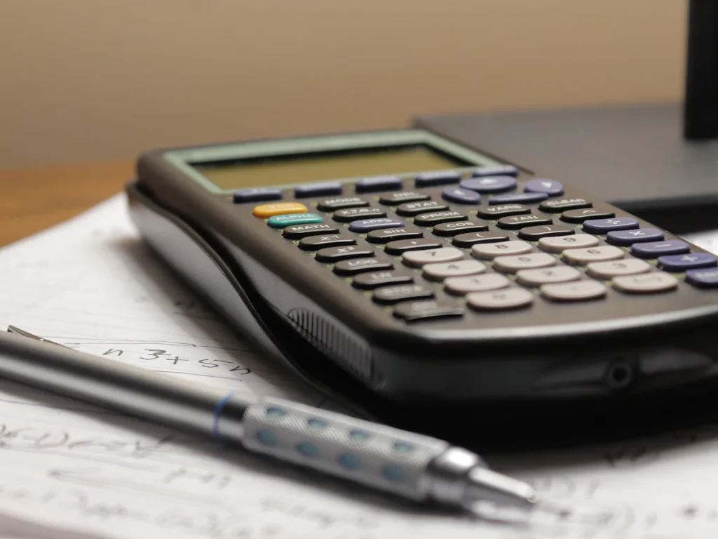 Calculator and pen on printed plans
